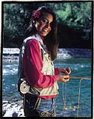 Fly fishing in Chile. A lady angler fishes a pool in the backyard of the Cumilahue Fishing Lodge, Chile. The flower is a Copihue, Chile&acute;s national flower.